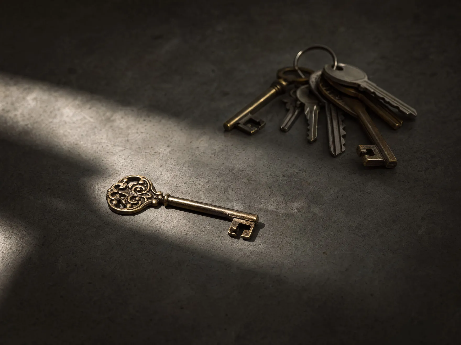 A single key resting apart from a ring of many others, isolated in light.