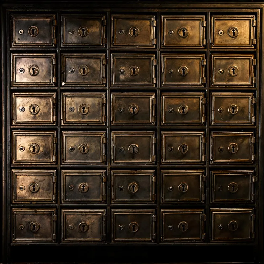 A wall of identical brass post-office boxes each with its own lock, representing the final MCP specification in which every request stands alone with no session carried between them.